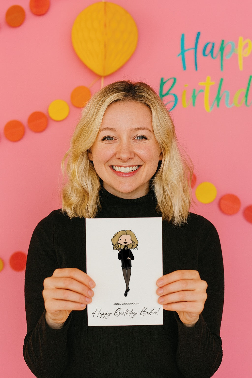 Person holding a personalised birthday card with a pink background and colorful decorations.