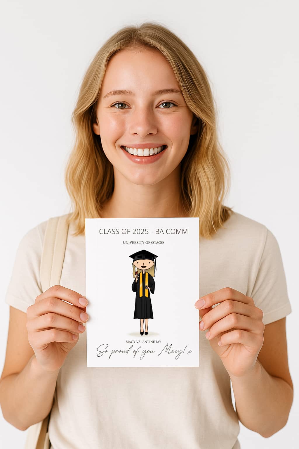 Woman holding a graduation-themed card with a printed design on a white background