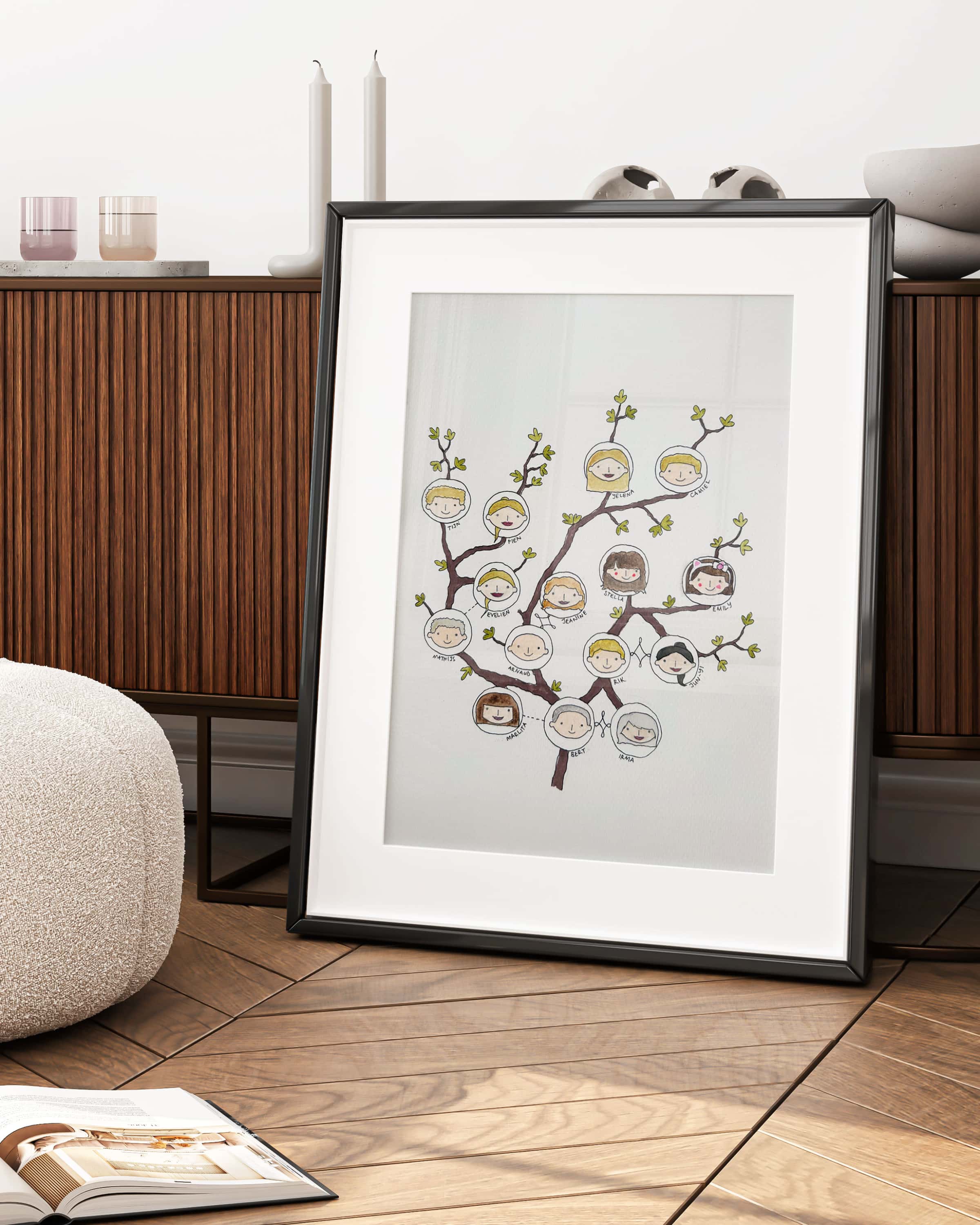 Framed artwork of a family tree on a wooden floor with candles and a cabinet in the background.