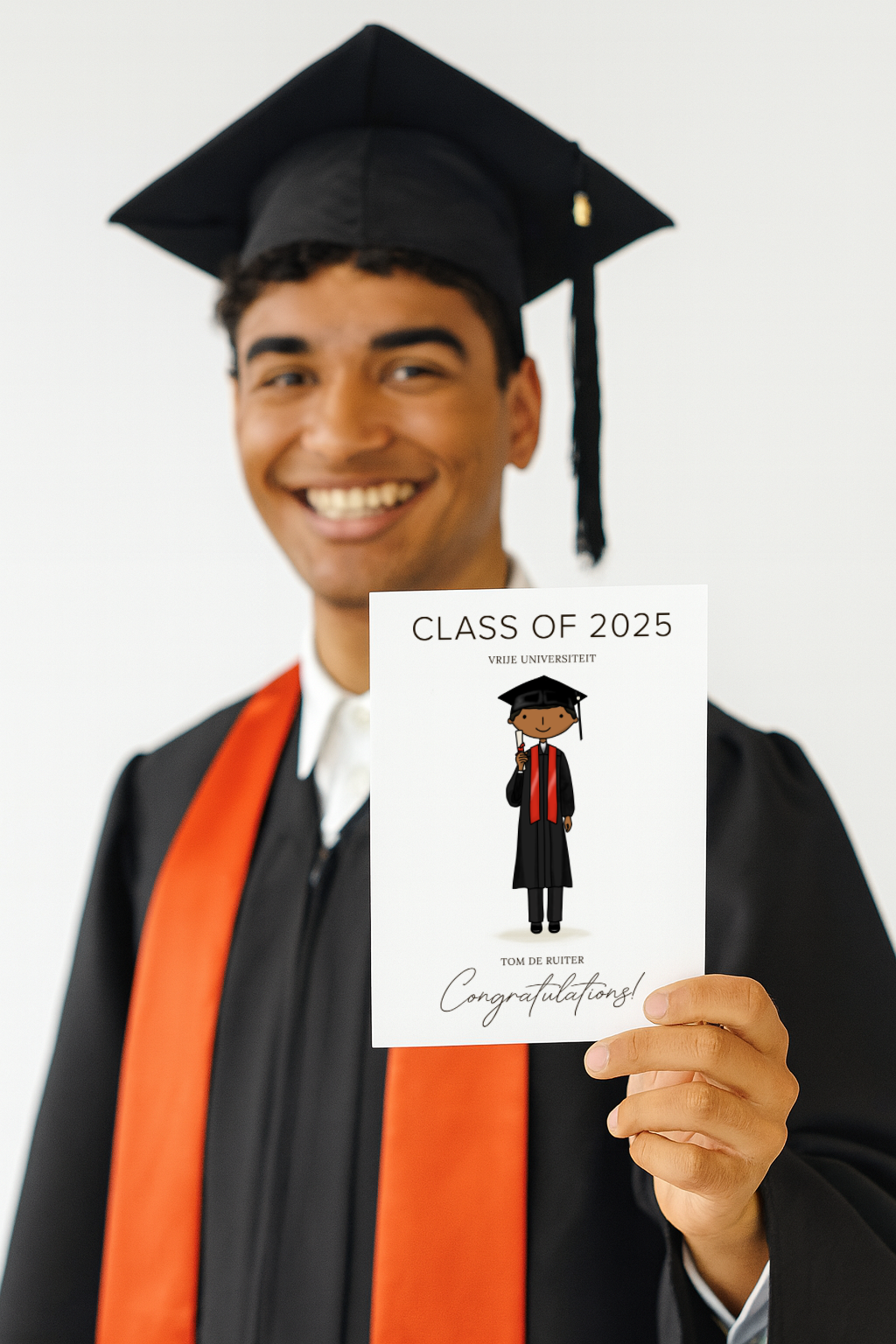 Graduating student holding a 'Class of 2025' congratulations card with a custom illustration of himself.