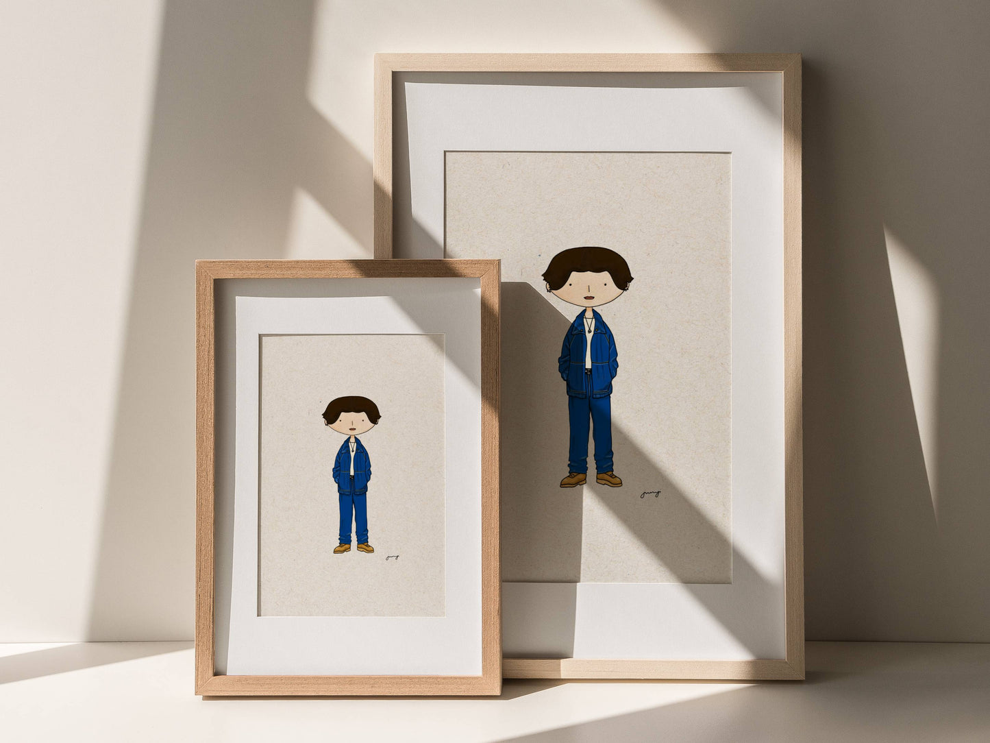 Two framed illustrations of Korean idol Jungkook in a suit on a light background