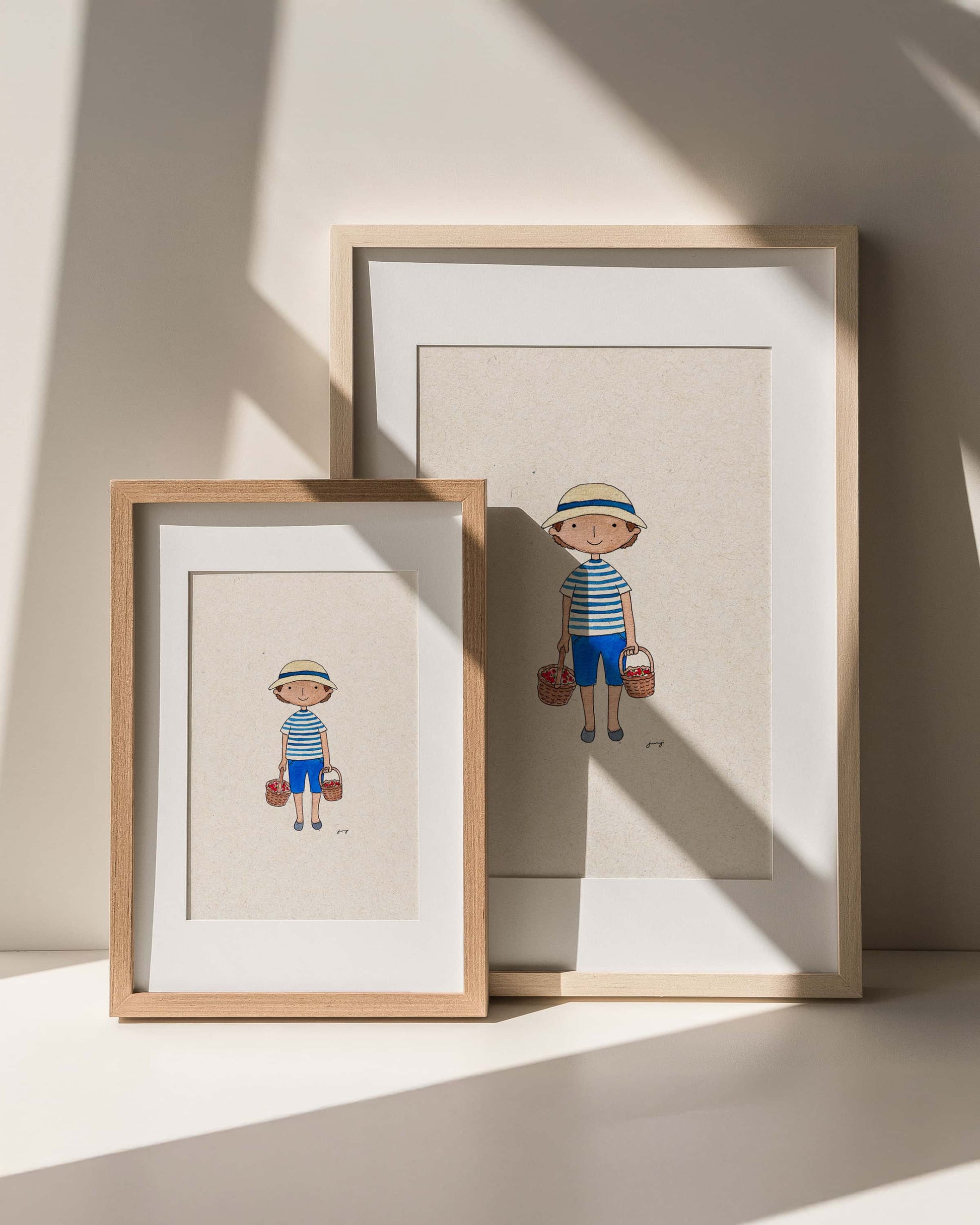 Two framed illustrations of a child in a striped shirt and shorts on a neutral background