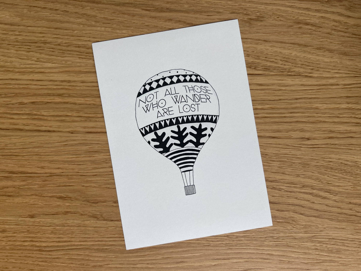 Art print with a black and white illustration of a hot air balloon and a traveller's quote by J.R.R. Tolkien