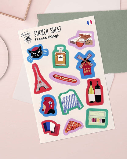 Sheet of stickers with French-themed designs on a light pink background