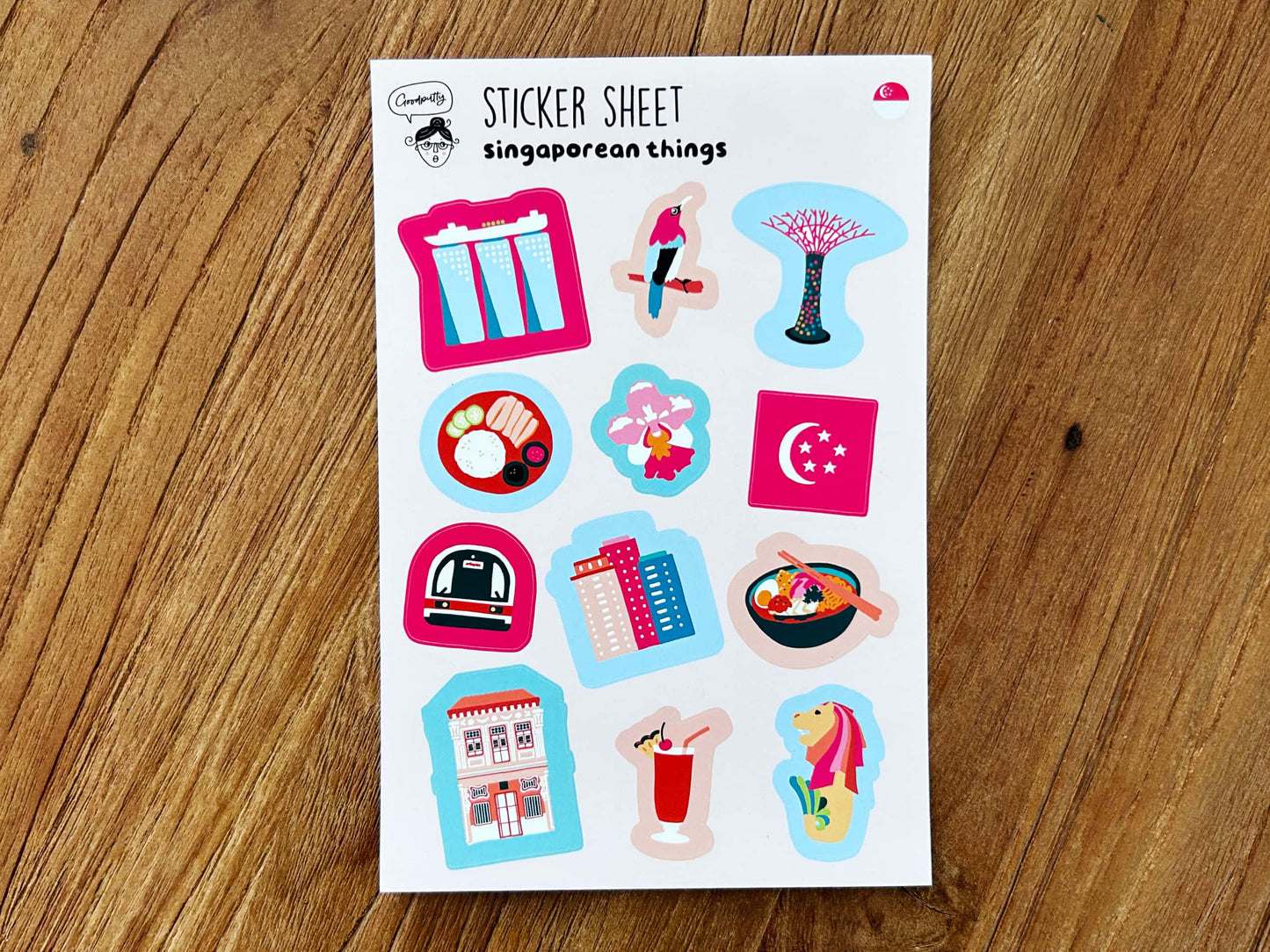 Sheet of Singapore-themed stickers on a wooden surface